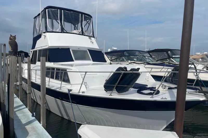 Slide: The Image of 1985 Marinette DC 39 boat docked at marina, featuring a sleek design and spacious deck. - 1