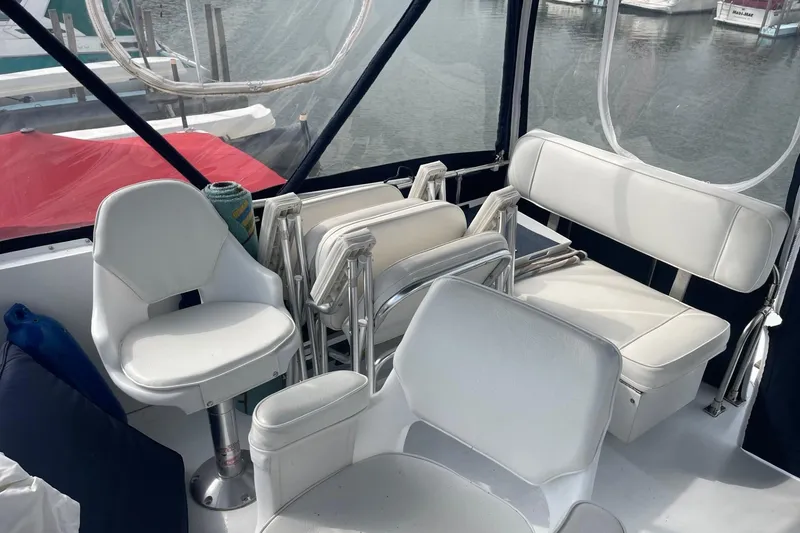Slide: The Image of 1985 Marinette DC 39 boat interior with white seating and marina view. - 10