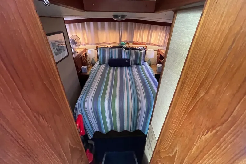 Slide: The Image of Cozy bedroom interior of 1985 Marinette DC 39 boat with striped bedding and wooden accents. - 14