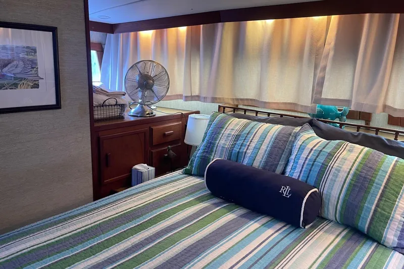 Slide: The Image of Cozy bedroom interior of 1985 Marinette DC 39 boat with striped bedding and fan. - 18