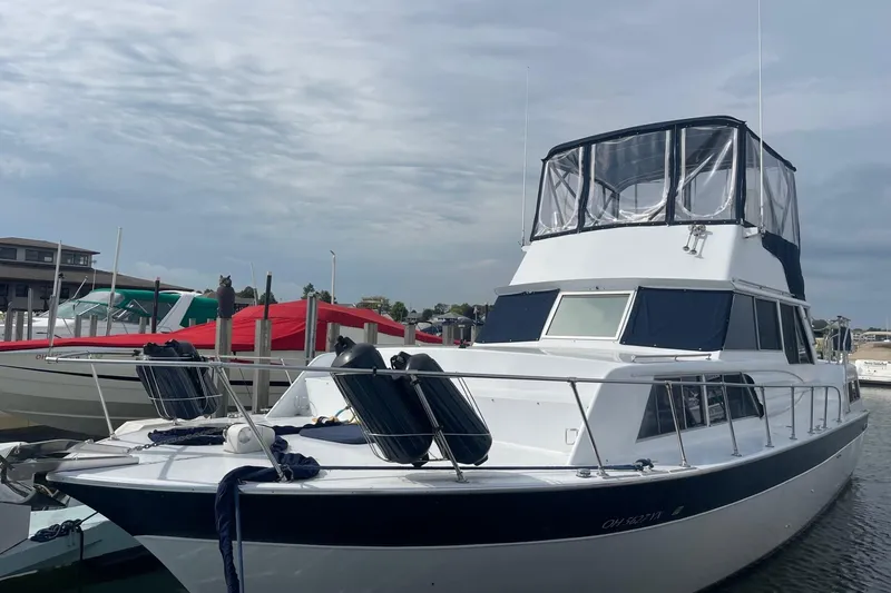 Slide: The Image of 1985 Marinette DC 39 boat docked at marina under cloudy sky. - 2