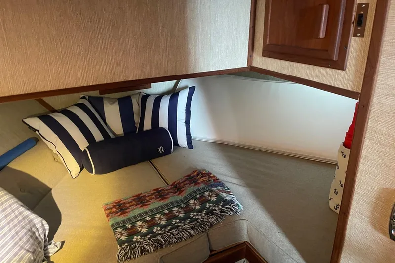 Slide: The Image of Cozy cabin interior of 1985 Marinette DC 39 with striped pillows and a colorful blanket. - 31