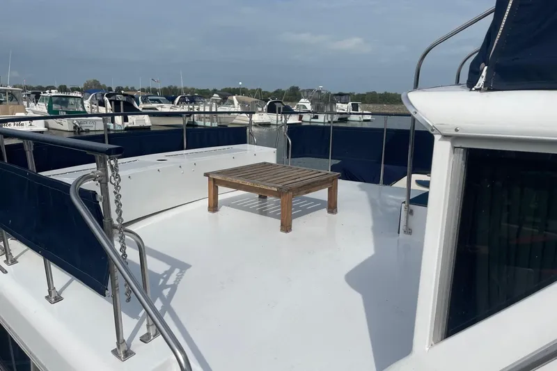 Slide: The Image of 1985 Marinette DC 39 boat deck with wooden table, docked at marina. - 5