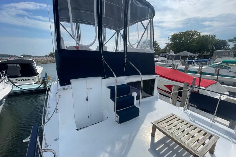 Slide: The Image of 1985 Marinette DC 39 boat docked, featuring blue canopy and wooden deck furniture. - 6