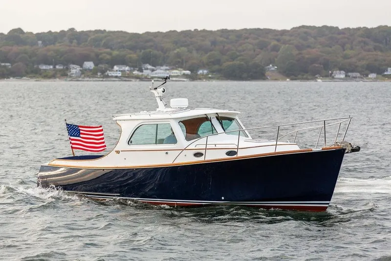 Slide: The Image of 2004 Hinckley Picnic Boat EP cruising with American flag on water. - 1