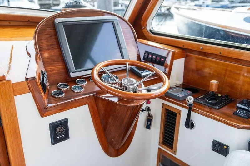 Slide: The Image of Helm of 2004 Hinckley Picnic Boat EP with wooden steering wheel and navigation controls. - 14