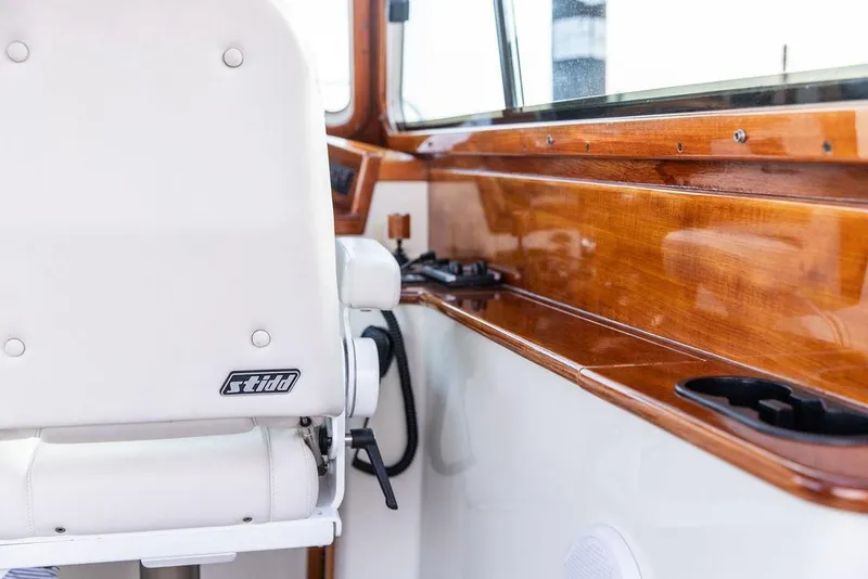 Slide: The Image of Interior of 2004 Hinckley Picnic Boat EP with white Stidd seat and polished wood finish. - 17