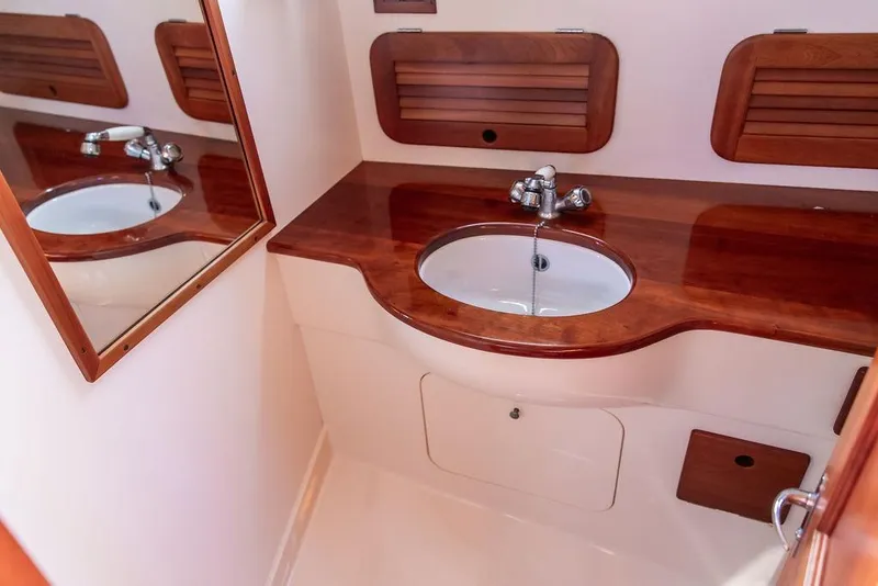 Slide: The Image of 2004 Hinckley Picnic Boat EP bathroom with wooden countertop and mirror. - 23