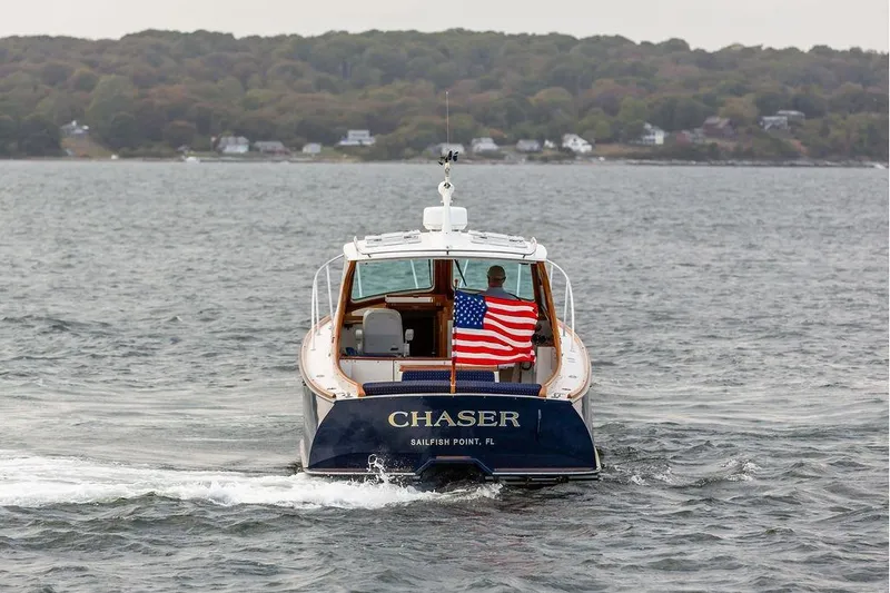 Slide: The Image of Hinckley Picnic Boat EP 2004 cruising with American flag on water, rear view. - 26