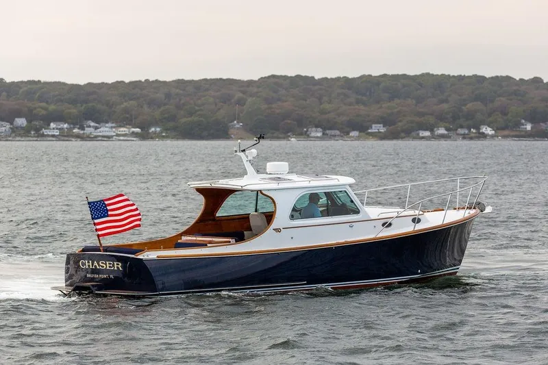 Slide: The Image of 2004 Hinckley Picnic Boat EP cruising on water with American flag. - 2