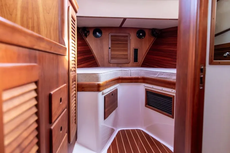 Slide: The Image of Interior of 2004 Hinckley Picnic Boat EP with wooden cabinetry and cozy seating area. - 22