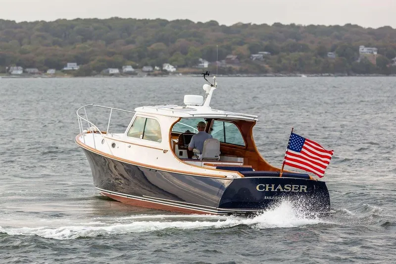 Slide: The Image of 2004 Hinckley Picnic Boat EP cruising with American flag on open water. - 3
