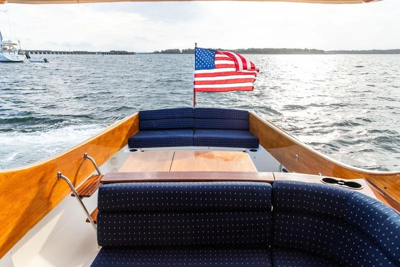 Slide: The Image of Hinckley Picnic Boat EP 2004 with American flag, cruising on open water. - 7