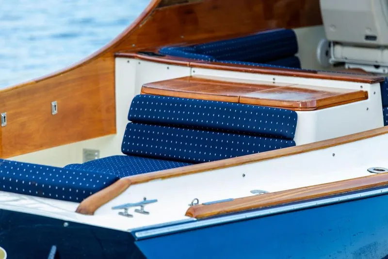 Slide: The Image of 2004 Hinckley Picnic Boat EP with blue cushioned seating and wooden accents. - 8