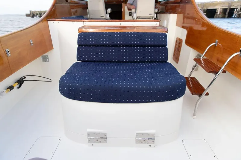 Slide: The Image of 2004 Hinckley Picnic Boat EP interior with blue cushioned seating and wooden accents. - 9