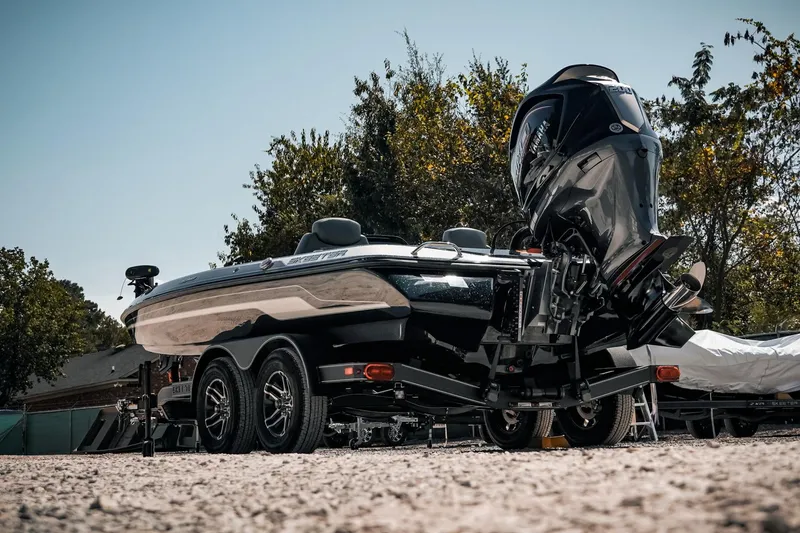 Slide: The Image of 2024 Skeeter ZX200 boat on trailer, parked outdoors with trees in background. - 21