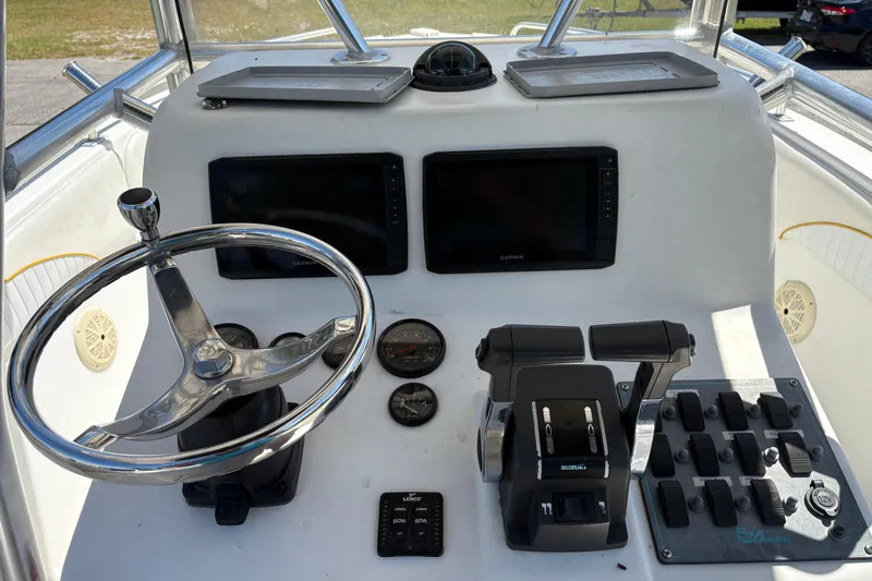 Slide: The Image of 2004 Sea Chaser 2300 Offshore boat dashboard with steering wheel and navigation controls. - 10