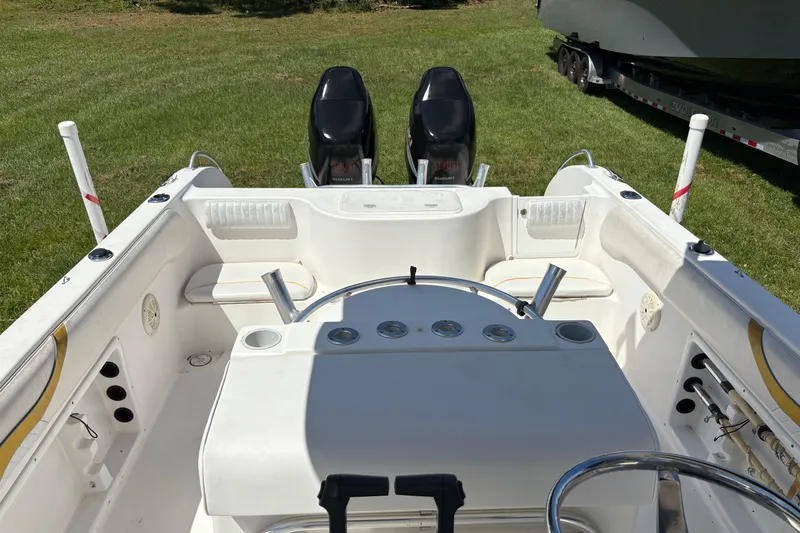 Slide: The Image of 2004 Sea Chaser 2300 Offshore boat interior with dual Suzuki engines on grass. - 19