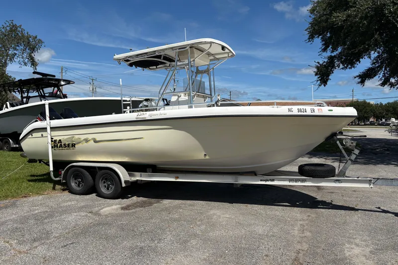 Slide: The Image of 2004 Sea Chaser 2300 Offshore boat on trailer, parked outdoors under clear sky. - 3