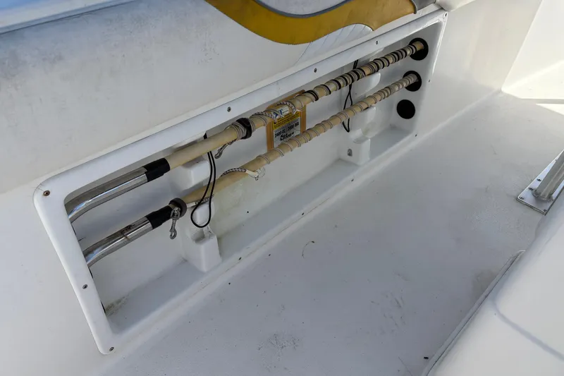 Slide: The Image of 2004 Sea Chaser 2300 Offshore boat interior with rod holders and storage compartment. - 9