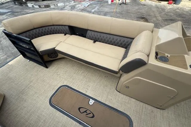 Slide: The Image of 2023 Harris Sunliner 250 boat interior with beige seating and storage compartments. - 10