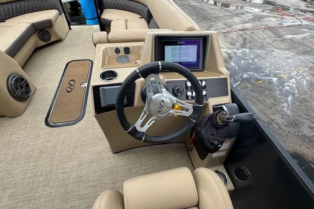 Slide: The Image of 2023 Harris Sunliner 250 boat interior with steering wheel and control panel. - 14