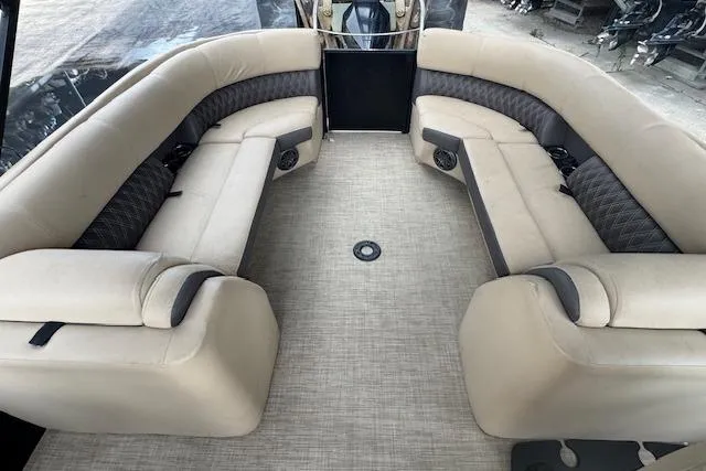 Slide: The Image of 2023 Harris Sunliner 250 boat interior with beige seating and spacious layout. - 16