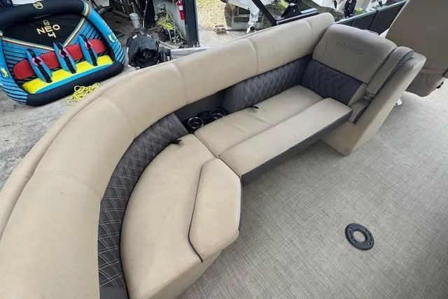 Slide: The Image of 2023 Harris Sunliner 250 boat interior with beige seating and cup holders. - 17