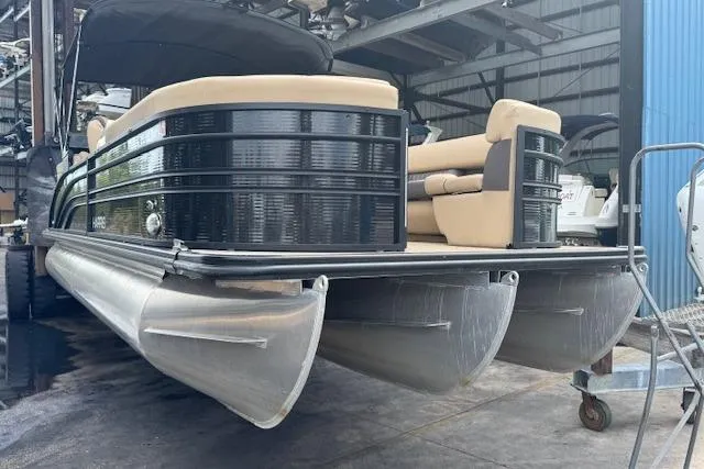 Slide: The Image of 2023 Harris Sunliner 250 pontoon boat in a storage facility. - 3