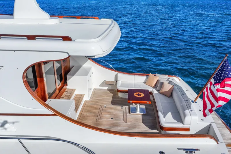 Slide: The Image of Luxurious 2023 Vicem 65 Classic yacht with elegant deck seating and American flag. - 6