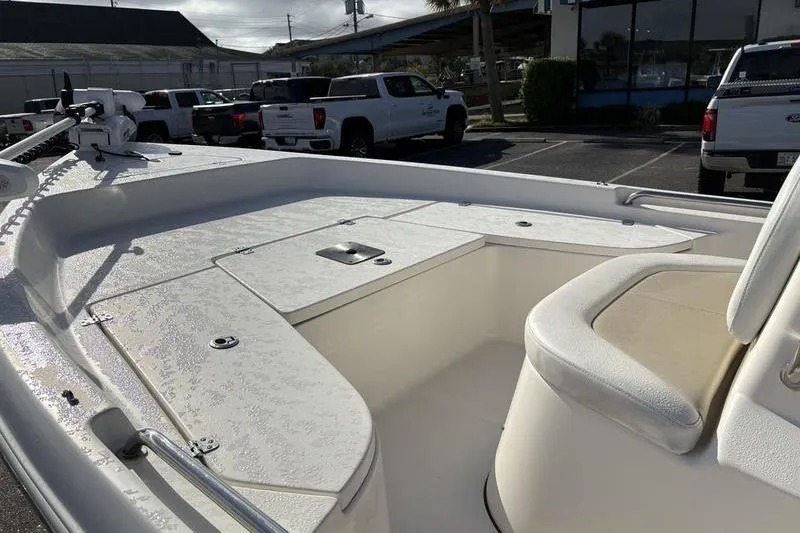 Slide: The Image of 2025 Bulls Bay 2000 boat interior with seating and storage, parked outdoors. - 19