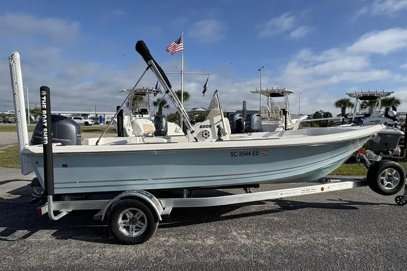 Slide: The Image of 2025 Bulls Bay 2000 boat on trailer, parked outdoors with flags in the background. - 5