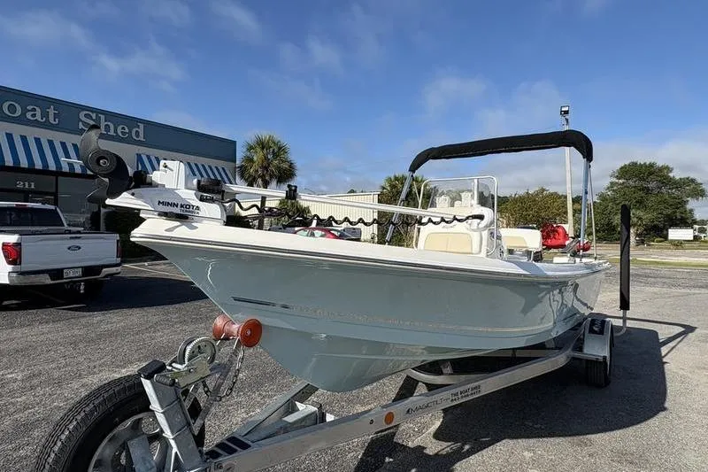 Slide: The Image of 2025 Bulls Bay 2000 boat on trailer, parked outside a boat shed under a clear sky. - 7