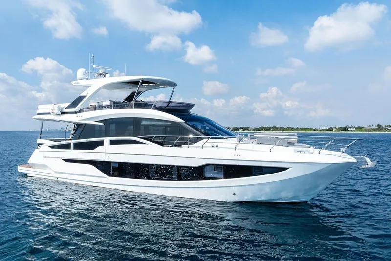 Slide: The Image of 2022 Galeon 640 Fly yacht cruising on open water under a clear sky. - 1