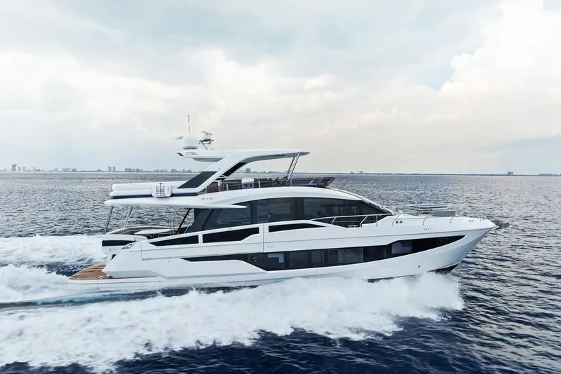 Slide: The Image of 2022 Galeon 640 Fly yacht cruising on open water under a cloudy sky. - 16