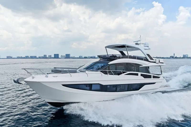 Slide: The Image of 2022 Galeon 640 Fly yacht cruising on open water under a cloudy sky. - 17