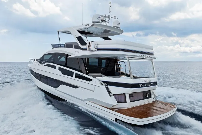 Slide: The Image of 2022 Galeon 640 Fly yacht cruising on open water under a cloudy sky. - 19