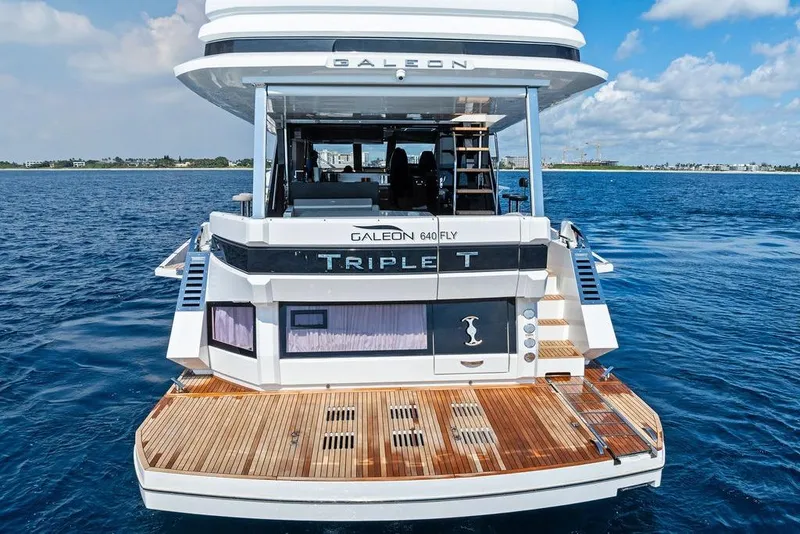 Slide: The Image of 2022 Galeon 640 Fly yacht on open water, rear view with wooden deck. - 9