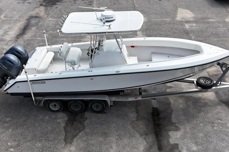 Slide: The Image of 2003 Jupiter 27 boat on trailer with dual Yamaha engines, parked on asphalt. - 10
