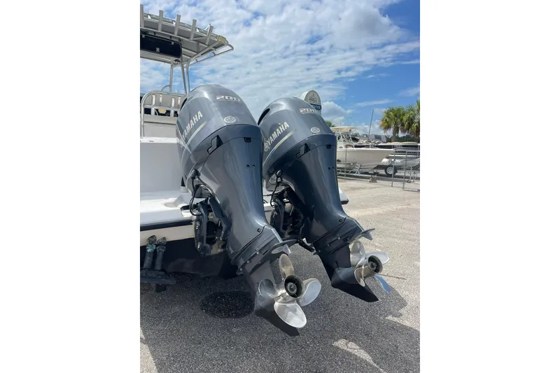 Slide: The Image of Twin Yamaha outboard motors on a 2003 Jupiter 27 boat under a clear sky. - 19