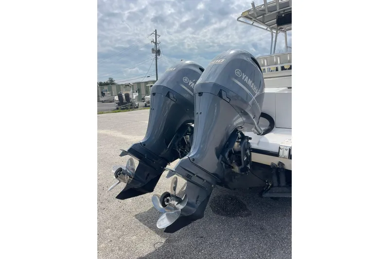 Slide: The Image of Twin Yamaha outboard motors on a 2003 Jupiter 27 boat, parked outdoors. - 20