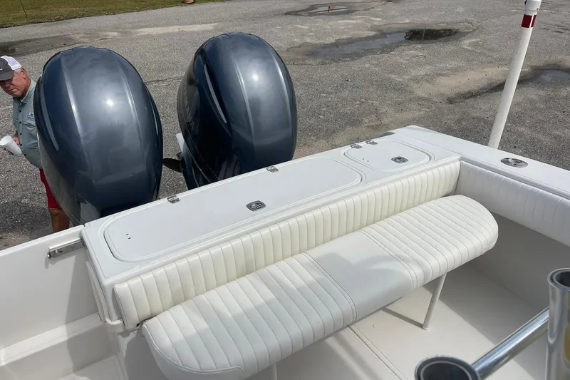 Slide: The Image of 2003 Jupiter 27 boat with dual engines and white seating on a concrete surface. - 21