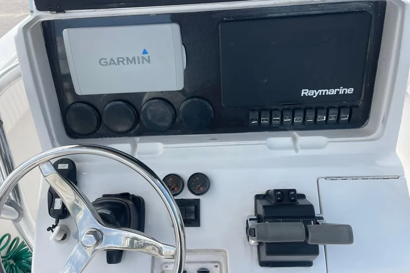 Slide: The Image of Center console of a 2003 Jupiter 27 boat with rod holders and steering wheel. - 25