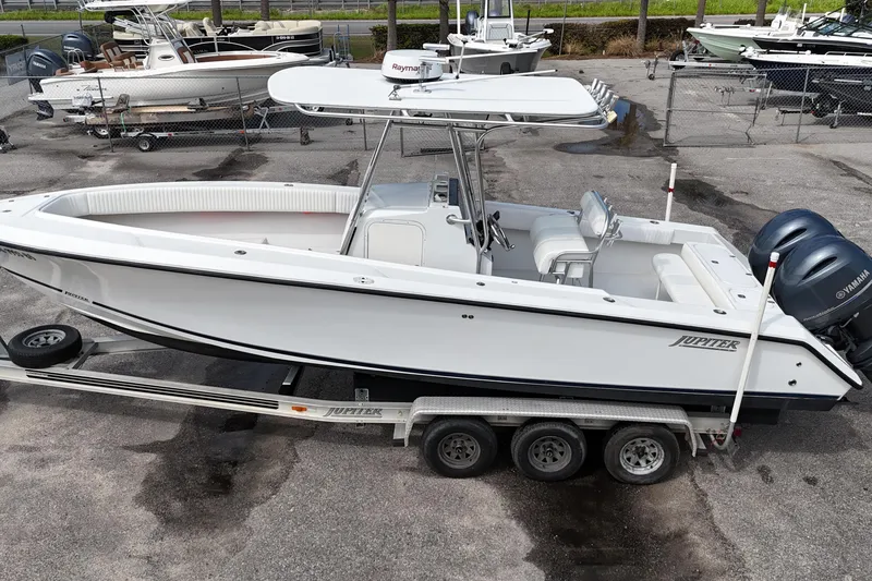 Slide: The Image of 2003 Jupiter 27 boat on trailer with dual Yamaha engines, parked in a marina. - 3