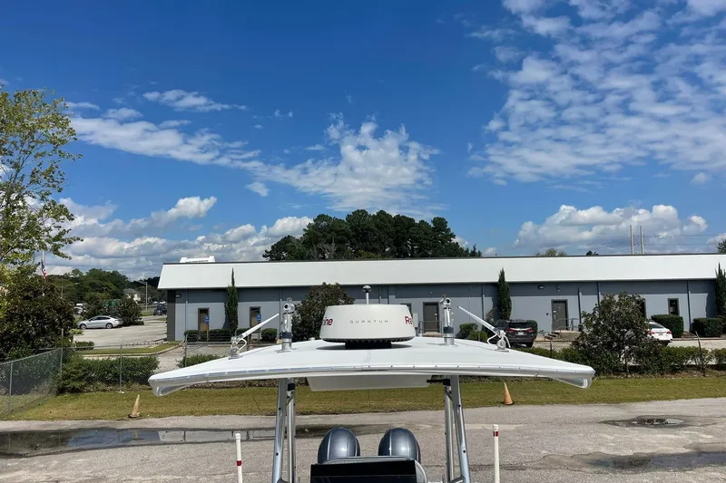 Slide: The Image of Boat with radar equipment, Jupiter 27 model, parked near industrial building under blue sky. - 33