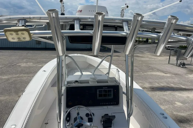 Slide: The Image of 2003 Jupiter 27 boat console with steering wheel and rod holders under clear sky. - 34