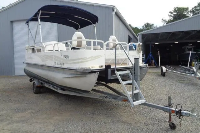 The Image of 2008 Bentley Pontoons 200 CRUISE boat on trailer, parked outside a metal building. - 1