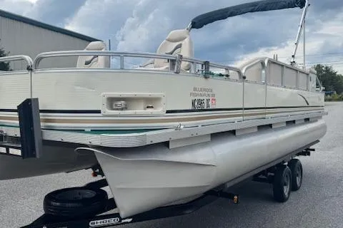 Slide: The Image of 2005 Tahoe Fish-N-Fun 22 pontoon boat on trailer, parked outdoors. - 3