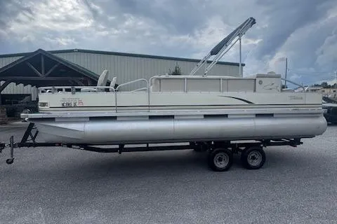 Slide: The Image of 2005 Tahoe Fish-N-Fun 22 pontoon boat on trailer, parked outdoors under cloudy sky. - 4