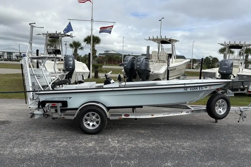Slide: The Image of 2025 East Cape EVO boat on trailer, parked outdoors with other boats in background. - 4